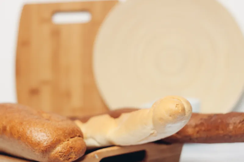 Буханка хлеба, разделочная доска, ложки, кухня, завтрак