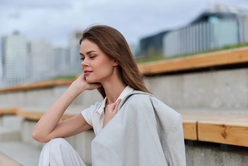 Calm pensive woman in light suit outdoors urban background spring season thoughtful emotion business concept