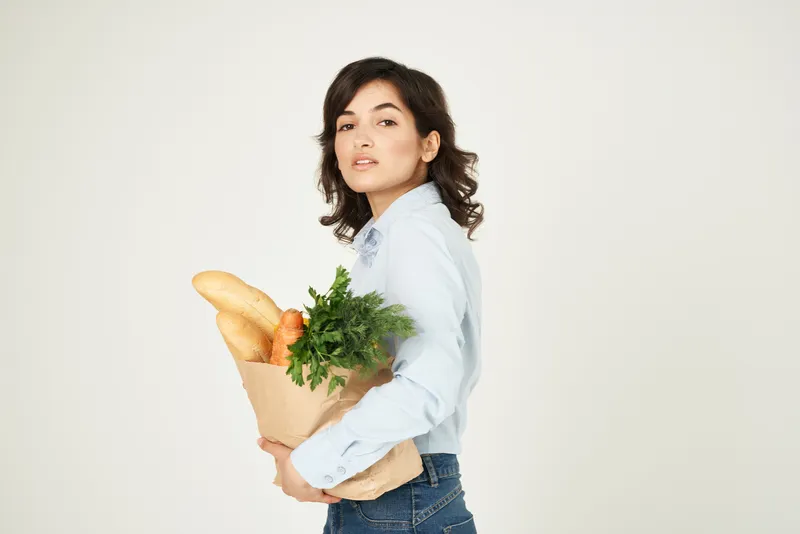 Женщина в синей рубашке с упаковкой продуктов, диетическая еда, покупки для здоровья