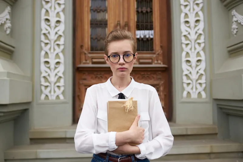 Студент на улице возле здания отдыхает, образование