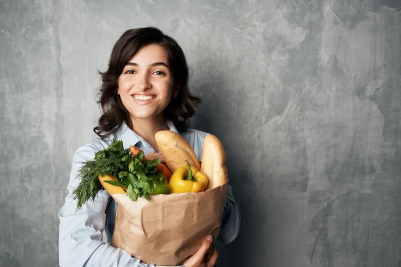 Женщина в синей рубашке с пакетом продуктов в супермаркете, еда, диета