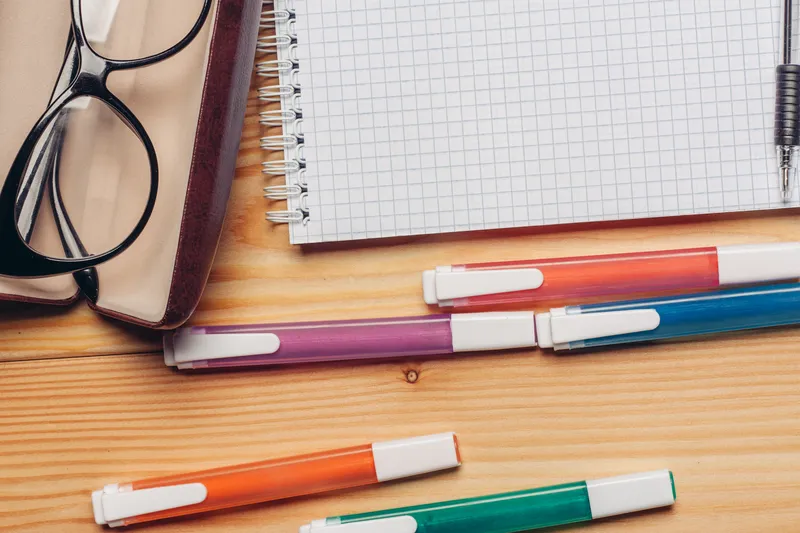 Очки в футляре на деревянном рабочем столе в офисе, крупный план