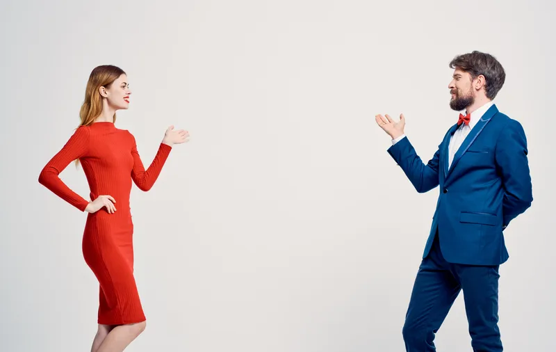 Женщина в красном платье или мужчина в костюме в студии