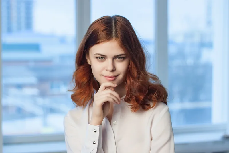 Жизнерадостная женщина-менеджер в офисе жестикулирует руками
