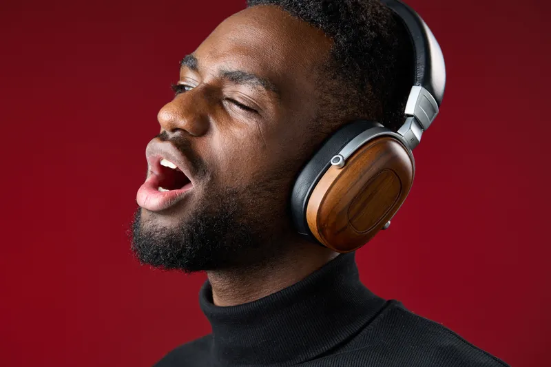 Young Black man enjoying music with headphones, expressing joy and passion in a vibrant setting, perfect for music and lifestyle themes