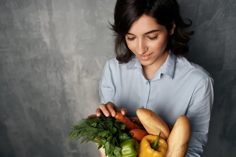 Симпатичная женщина с пакетом овощных продуктов, здоровое питание, диета