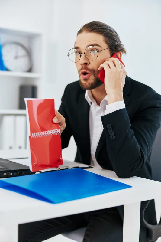Мужчина в костюме работает в офисе перед ноутбуком, руководитель