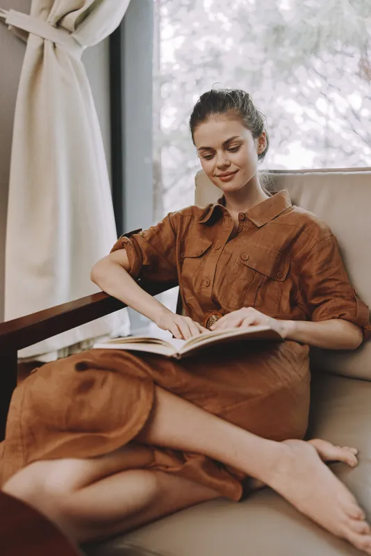 Молодая женщина наслаждается чтением книги в уютном, светлом помещении