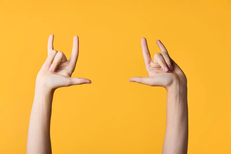 Hands frame an empty space against a bright orange backdrop, a creative gesture for photography, design and social media content, playful, dynamic composition and visual framing idea