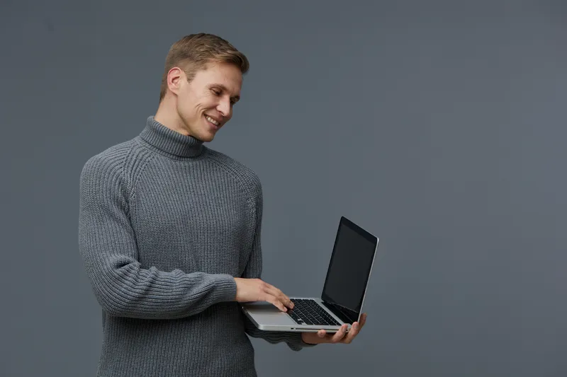 smiling man working laptop casual grey knitted sweater use computer internet digital nomad concept isolated dark background