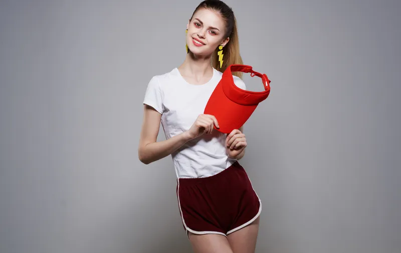 Спортивная женщина в красной кепке, серьги, фитнес, мода, роскошь