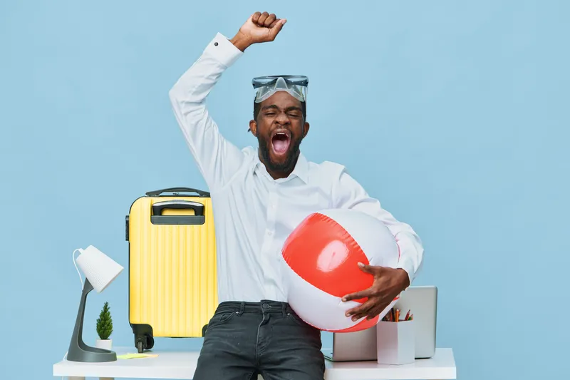 Joyful young African American man in white shirt plays with beach ball and sunglasses on a bright light blue background, summer vacation, leisure lifestyle, travel concept, happiness, bright color pal