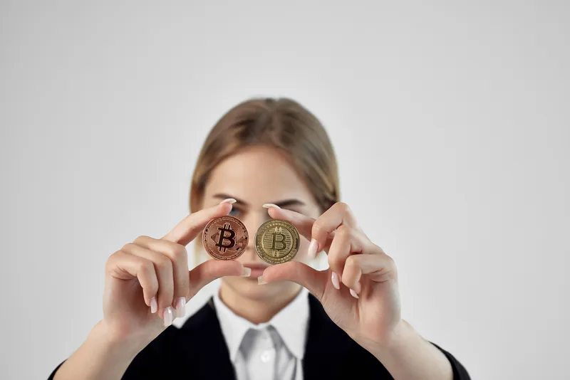 Бизнесвумен держит в руках биткоин-криптовалюту на изолированном фоне