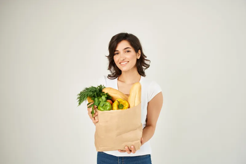 Женщина с пакетом продуктов, здоровая еда, супермаркет, светлый фон