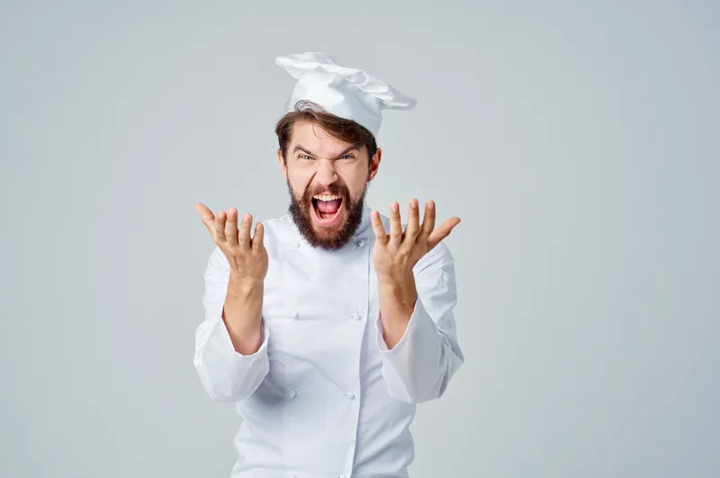 Мужчина в рабочей форме представляет профессию на кухне на светлом фоне