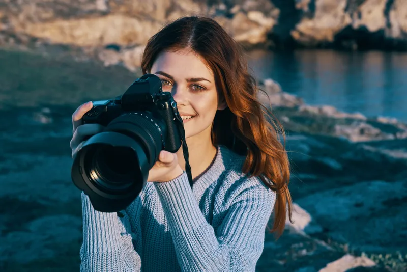 Женщина-фотограф на фоне природы, скалистые горы, приключение