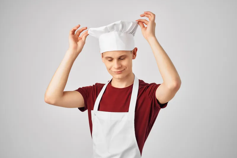 Мужчина в фартуке профессионально работает на кухне