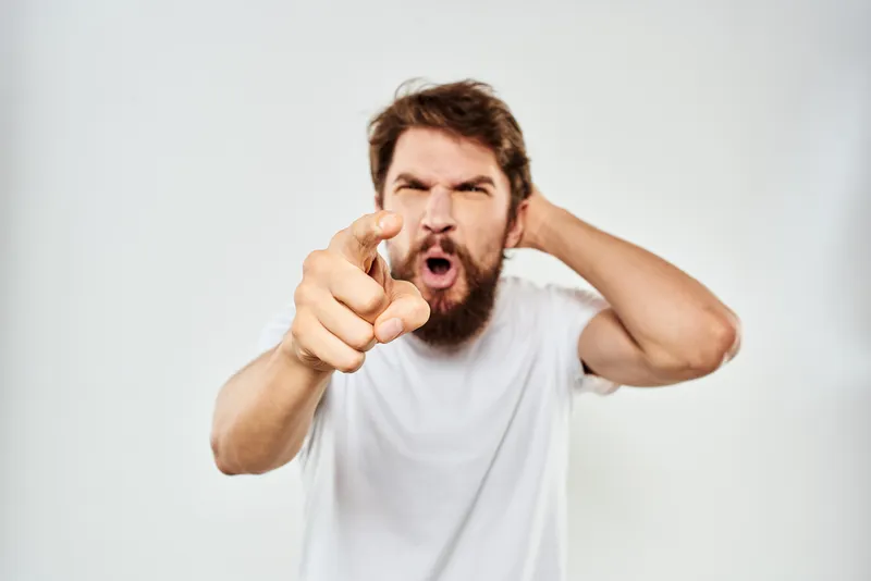 Эмоциональный мужчина с бородой жестикулирует руками, снятый крупным планом в студии