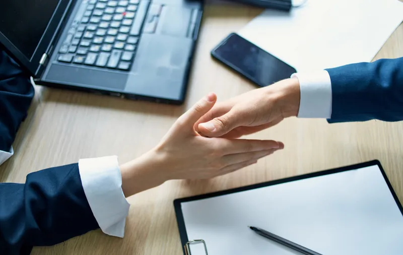 Сотрудники пожимают друг другу руки на работе в офисе, соглашение, документ, ноутбук