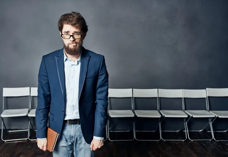 Мужчина в костюме, ожидающий собеседования при приеме на работу, испытывает эмоции