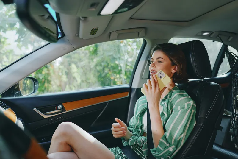 Car, driver, woman, smile a cheerful woman sits in the driver's seat with her hand confidently placed on the steering wheel, radiating joy and readiness for a journey ahead