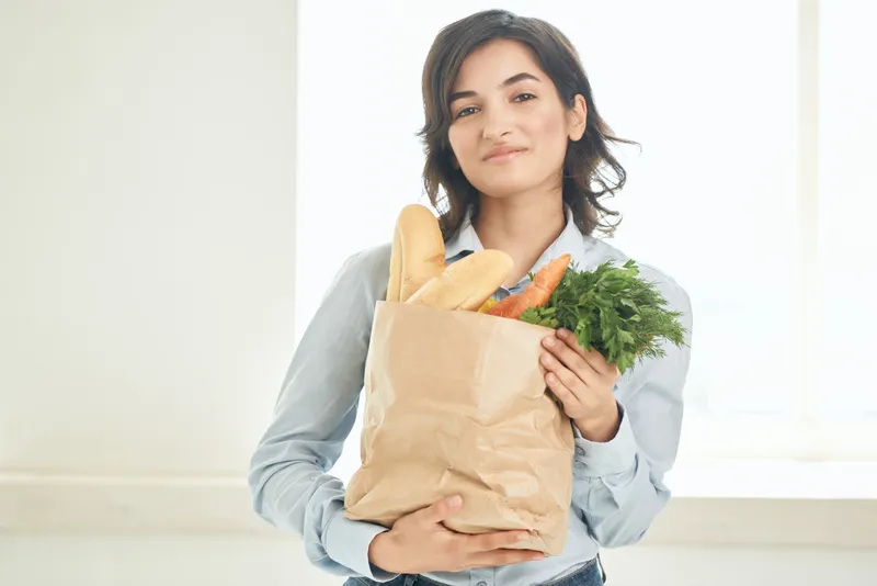 Женщина с пакетом продуктов на кухне, домохозяйка, овощи, здоровая пища