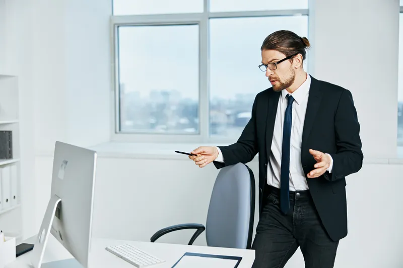 Офисный работник в костюме занимается офисной работой с использованием телефона и технологий