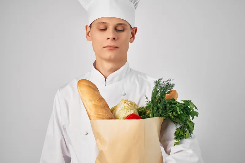 Шеф-повар занимается приготовлением еды, используя упаковку с продуктами