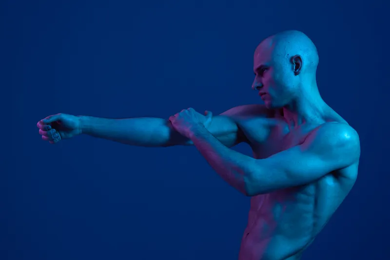 Artistic portrayal of a man with a striking blue light, showcasing a modern and captivating aesthetic through dynamic poses and color play.