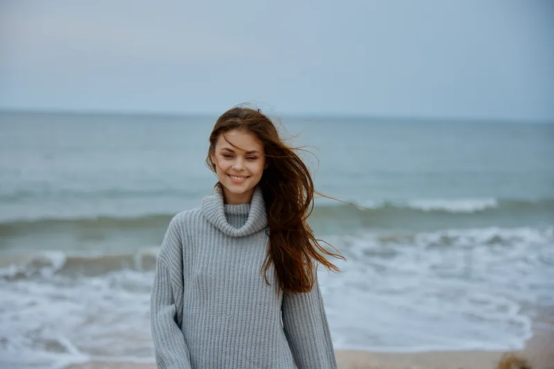 Жизнерадостная женщина в пасмурную погоду у моря, путешествие, свежий воздух, без изменений