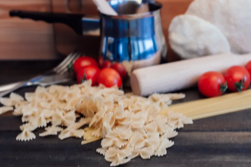 Итальянская кухня: паста, приготовление еды, деревянный стол, обед, помидоры черри