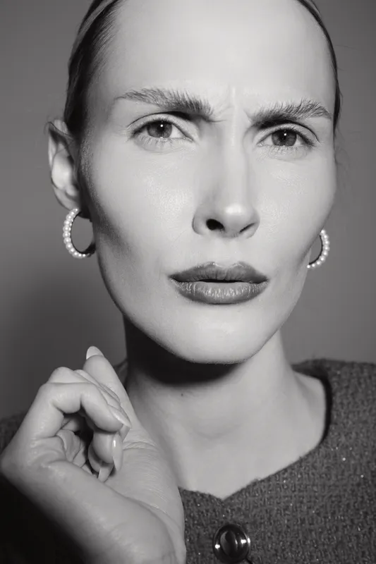 Close-up portrait of a fair skinned caucasian woman with earrings looking confused or skeptical, black and white photo.