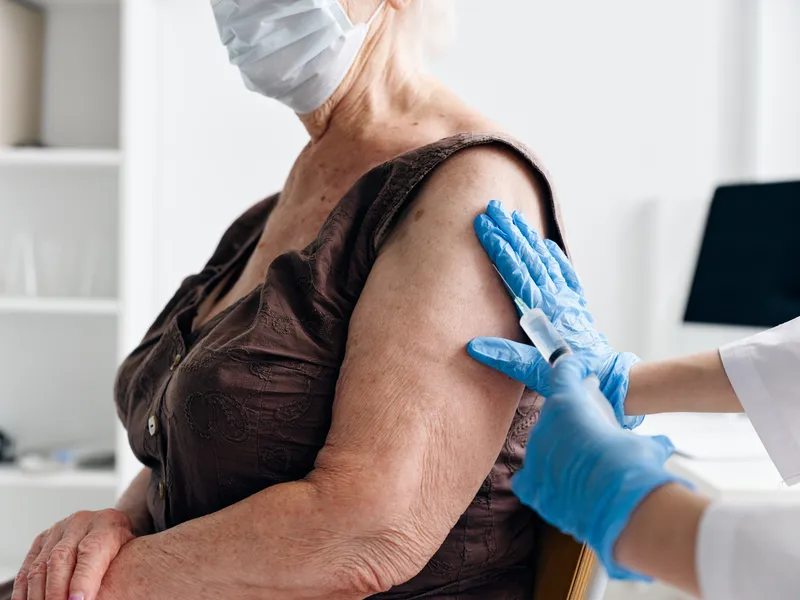 Пациентка в больнице держит паспорт вакцинации от COVID-19