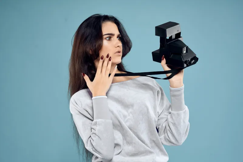 Женщина-фотограф с камерой на синем фоне