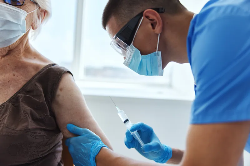 Врач со шприцем, паспорт covid-19, лечение пациента