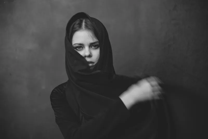 Портрет молодой женщины с тканью на голове, жестикулирующей руками