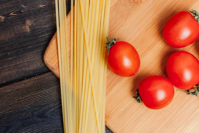 Ингредиенты для итальянской пасты: соус, продукты для приготовления на деревянном столе