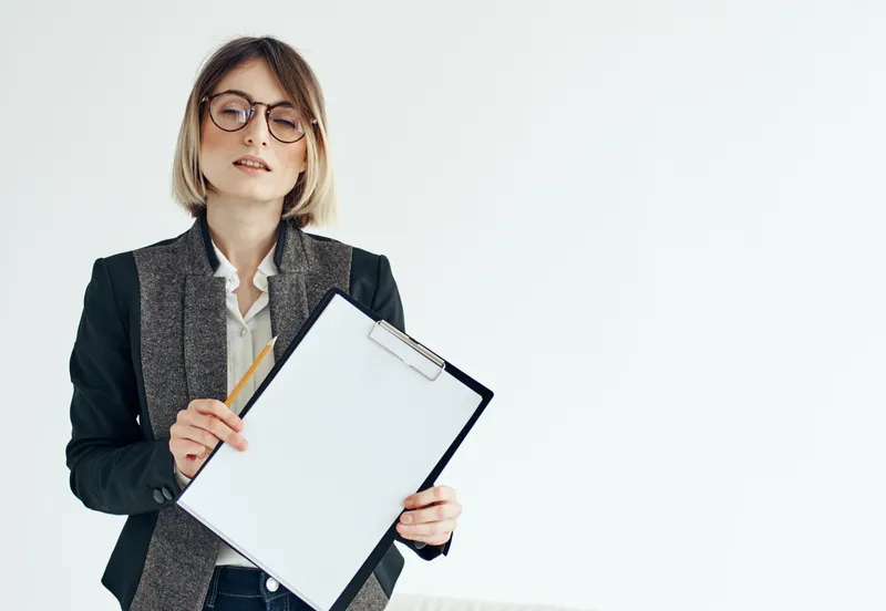 Деловая женщина в пиджаке, менеджер, модель, в очках и с белым листом бумаги