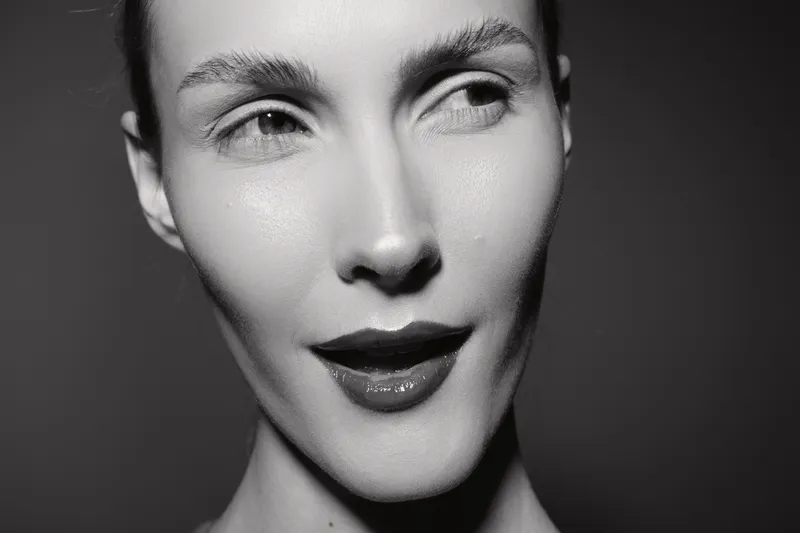 Close-up portrait of a young white woman with light skin and short hair looking sideways. Concept of beauty, expression, and monochrome photography.