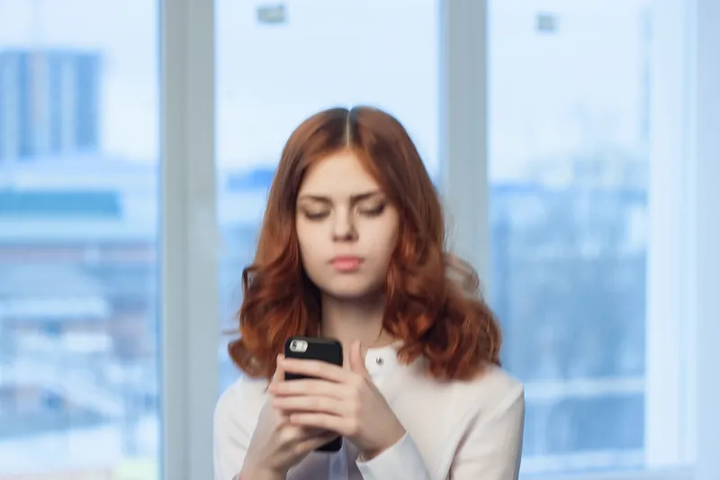 Деловая женщина в белой рубашке с телефоном в руках, общение, технологии, офис