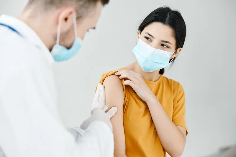 Медсестра делает укол в плечо женщине, вакцинация, инфекция, эпидемия