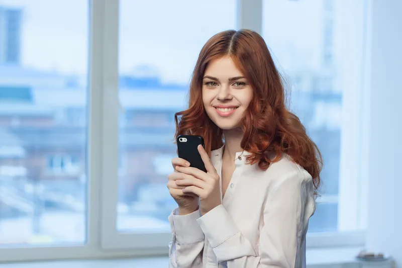 Деловая женщина в рубашке с телефоном в руках, работа, профессионалы, общение