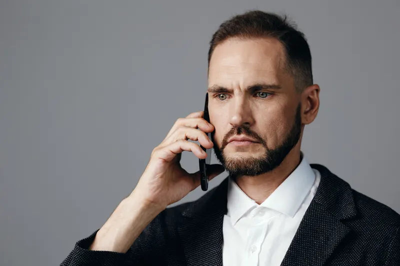 Professional business man on a call, conveying focus and confidence, captured against an isolated colored background that enhances a corporate mood.