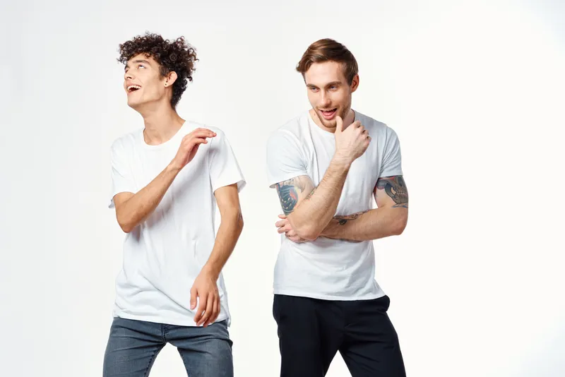 Весёлые друзья в футболках с ангелами стоят рядом, эмоции на изолированном фоне