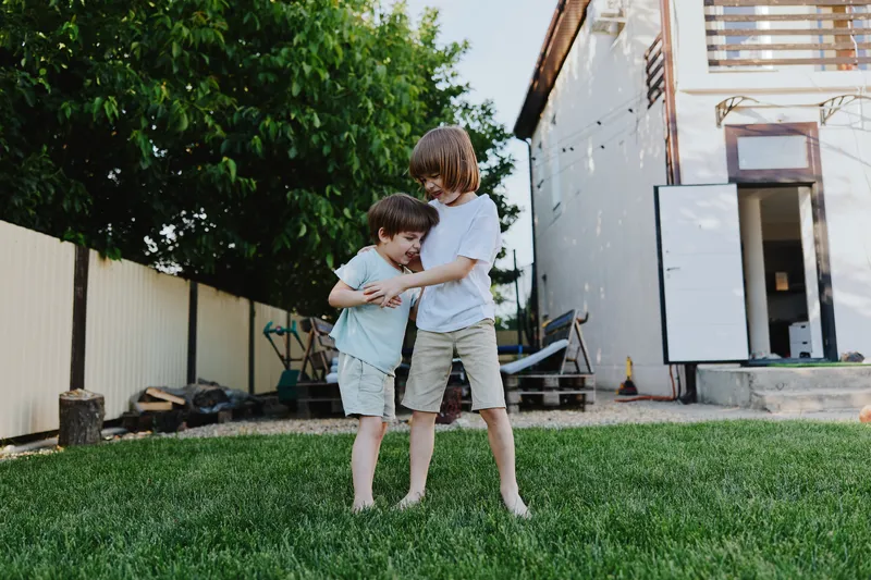 Joyful children playing together in a sunny garden, enjoying the warmth of spring, showcasing happiness and friendship in a vibrant outdoor setting.