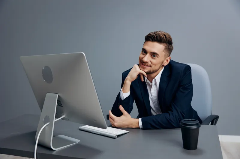 Красивый бизнесмен пьет кофе, он устал на работе с документами на столе