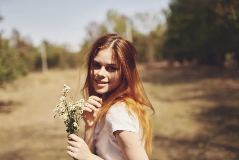 Женщина держит цветы на природе, летний образ жизни