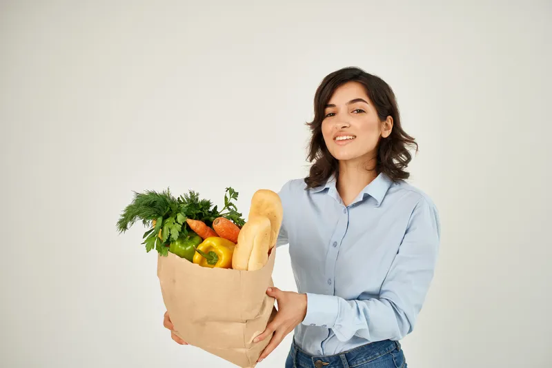 Милая брюнетка с пакетом продуктов из супермаркета