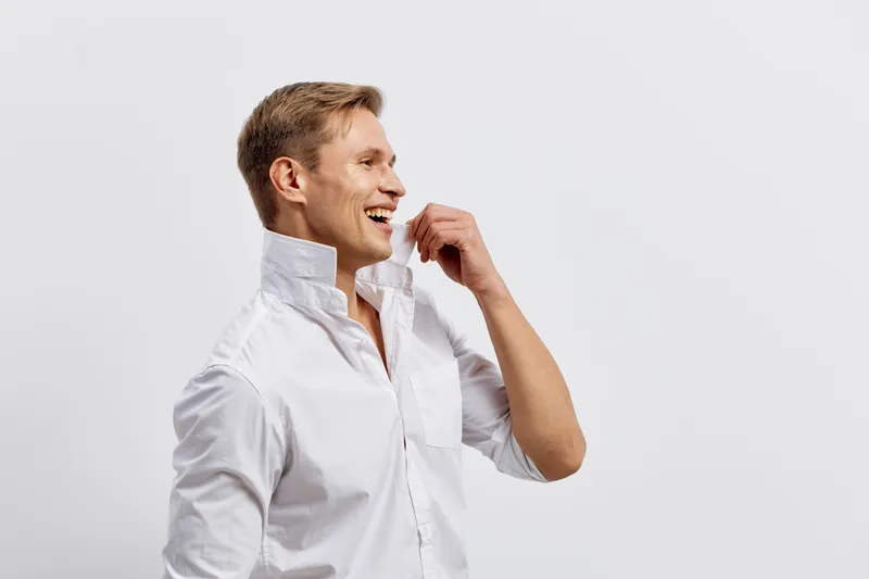 Smiling young caucasian man wear white shirt stand isolated on plain background look side profile happy positive emotion mental health concept