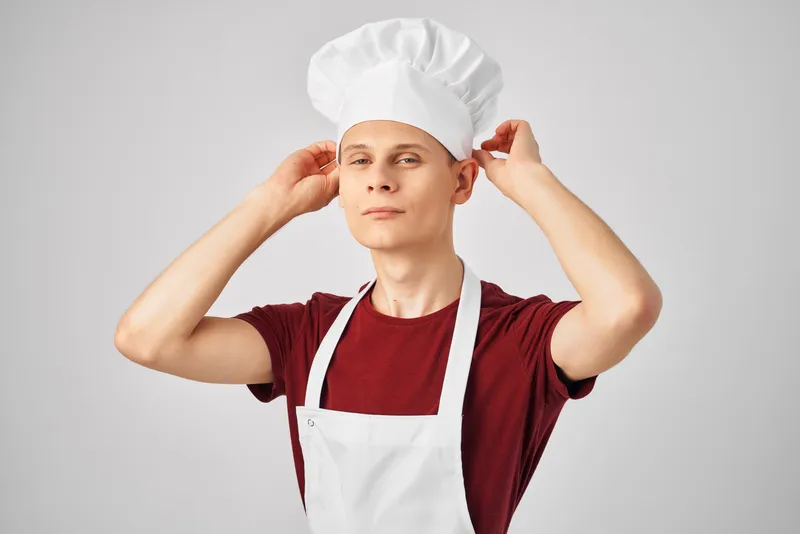 Мужчина в фартуке профессионально работает на кухне